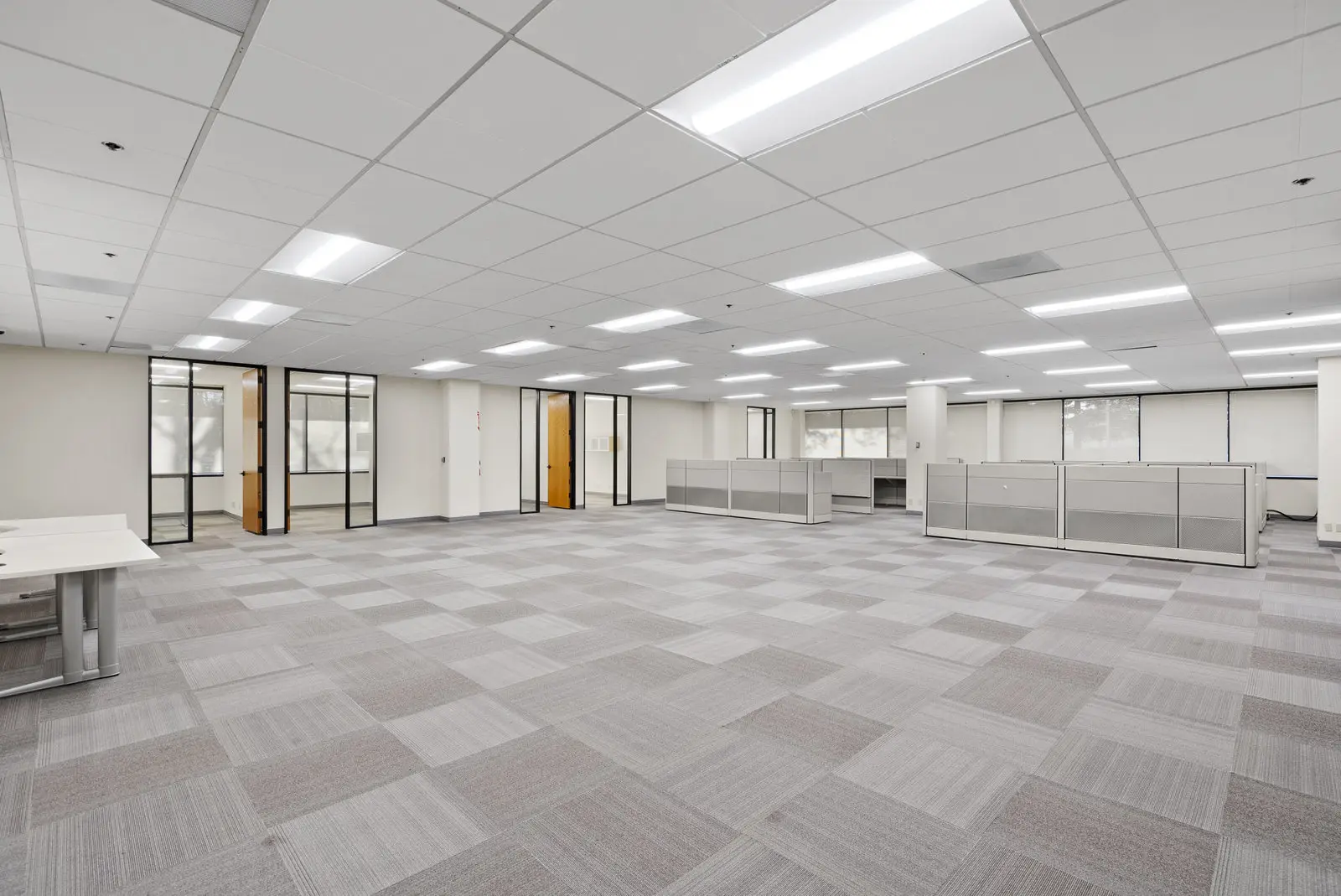 An open work area with carpet tile and glass offices